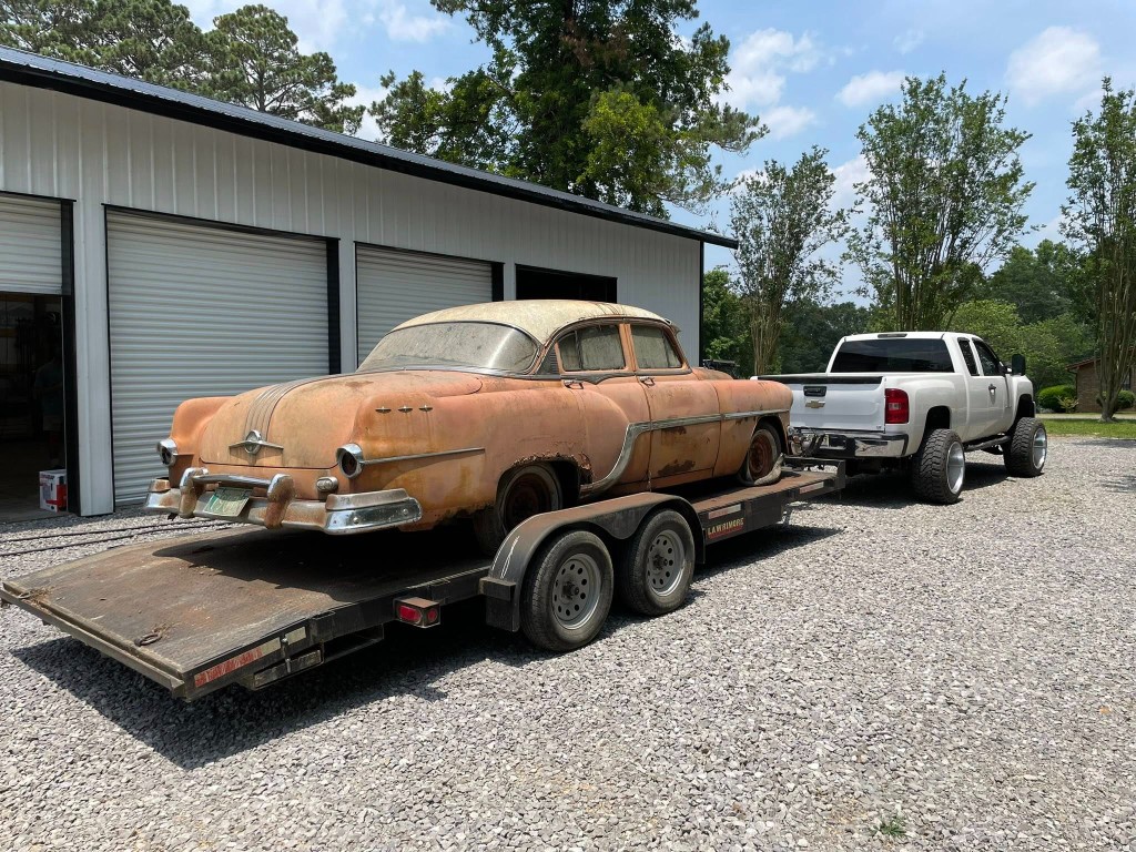 Classic car restoration project on transport trailer